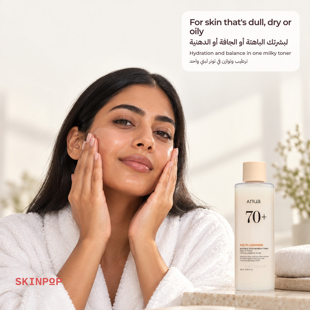 Woman in a white robe touching her face next to the Anua Rice 70 Glow Milky Toner