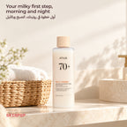 Anua Rice 70 Glow Milky Toner on a bathroom counter next to a wicker basket and rolled towels
