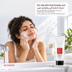 Woman washing her face with foam from the COSRX Salicylic Acid Daily Gentle Cleanser at a bathroom sink