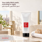 COSRX Salicylic Acid Daily Gentle Cleanser on a bathroom sink next to a gold faucet and towel