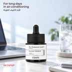 COSRX The Hyaluronic Acid 3 Serum on a desk next to a laptop and a glass of iced water