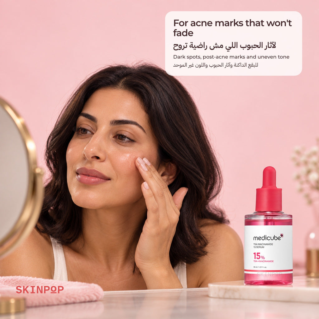 Woman touching her cheek in front of a mirror with the Medicube TXA Niacinamide 15 Serum beside her