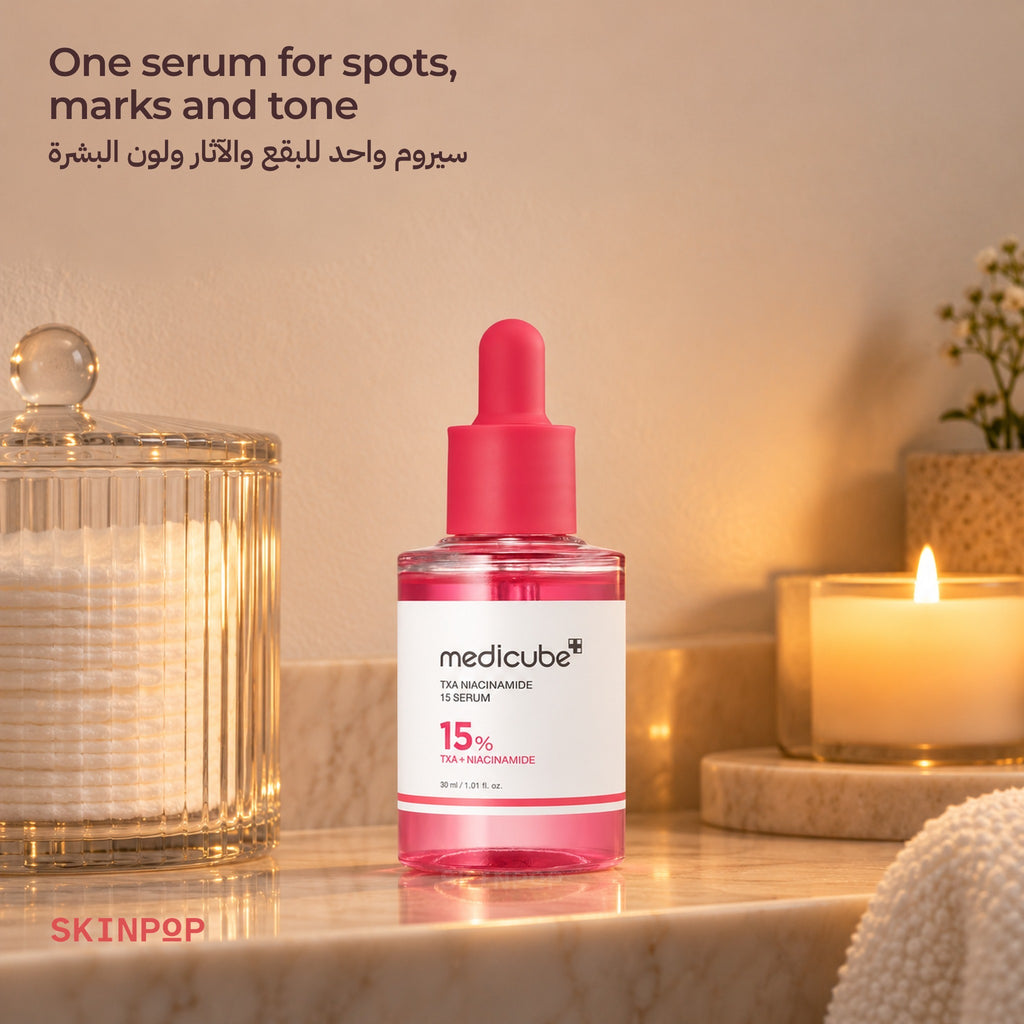 Medicube TXA Niacinamide 15 Serum on a vanity shelf next to a glass jar and a lit candle