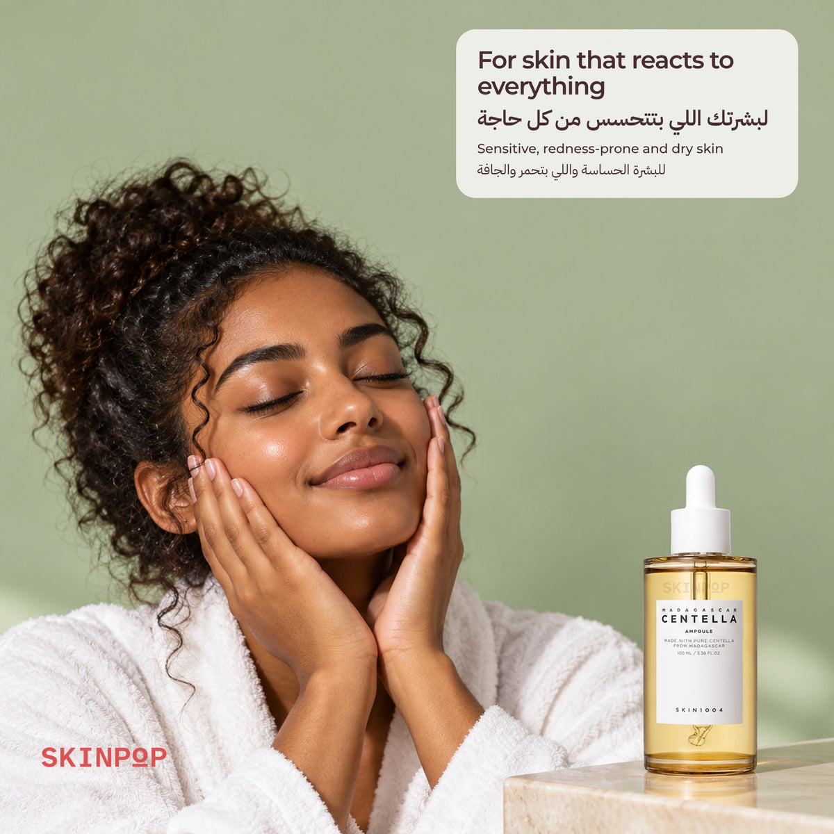 Woman with curly hair in a white robe touching her cheeks next to the SKIN1004 Madagascar Centella Ampoule