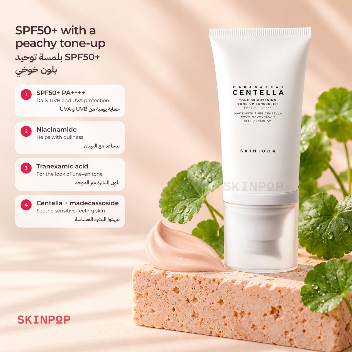 SKIN1004 Tone-Up Sunscreen tube on a peach stone block with fresh centella leaves