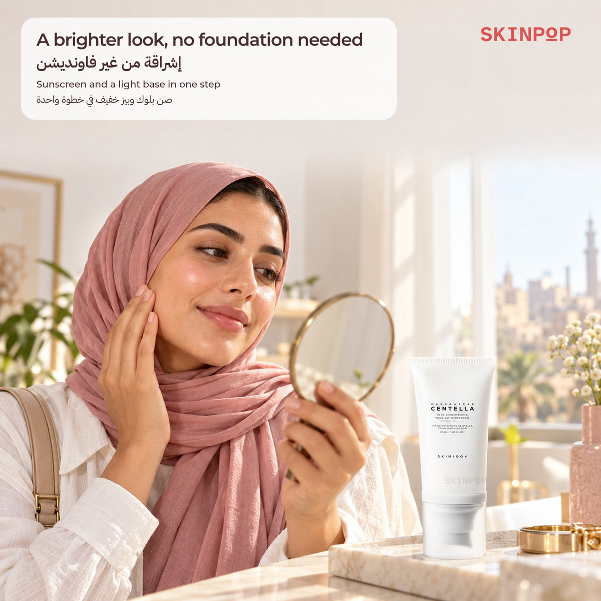 Woman holding a hand mirror and touching her cheek next to the SKIN1004 Tone-Up Sunscreen