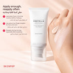 Swipe of SKIN1004 Tone-Up Sunscreen on the back of a hand with the tube behind it